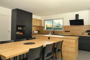 a kitchen with a large wooden table and chairs at L'HACIENDA DUO a romantic getaway with a private spa in Charavines