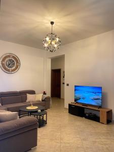 a living room with a couch and a flat screen tv at Villa Sota Divjakë in Divjakë