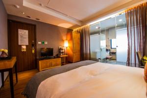 a hotel room with a bed and a television at Aqua Bella Hotel in Taipei +31 photos