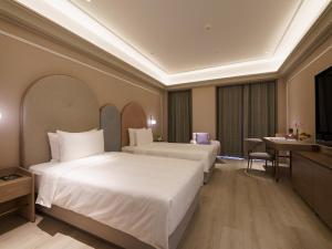 a hotel room with two beds and a table at Mercure Xi'an Stadium Hotel in Xi'an +67 photos