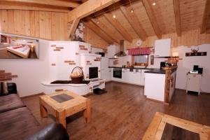 a large kitchen with white cabinets and a wooden ceiling at Almchalet Schneeberg in Mühlbach am Hochkönig
