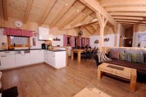 a kitchen and living room with a couch and a table at Almchalet Schneeberg in Mühlbach am Hochkönig +15 photos