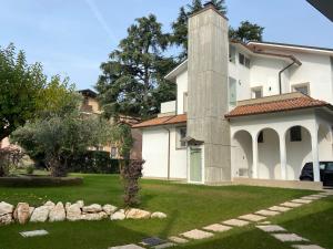 Una gran casa blanca con un patio de césped. en CAMELIA GUEST HOUSE Vimercate, en Vimercate