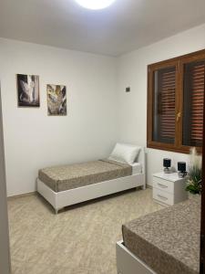 a bedroom with two beds and a window at Villa Sota Divjakë in Divjakë