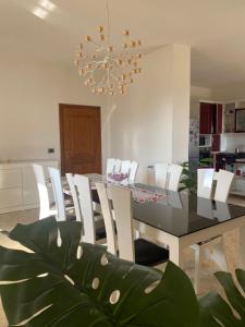 a dining room with a black table and white chairs at Villa Sota Divjakë in Divjakë