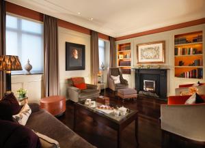a living room with a couch and a fireplace at St. James' Court, A Taj Hotel, London in London
