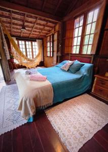 a bedroom with a bed in a room with windows at Chalé Candeia no Matutu in Aiuruoca
