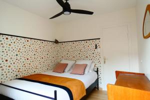 a bedroom with a bed and a ceiling fan at LAC CASA 60' Sixties-style flat with terrace overlooking the lake 300 m in Bilieu +13 photos