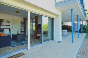 a glass extension of a house with a living room at LAC CASA 60' Sixties-style flat with terrace overlooking the lake 300 m in Bilieu