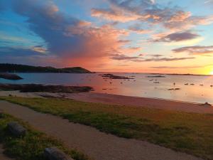 a sunset over a beach with birds in the water at Kub in Trélévern +8 photos