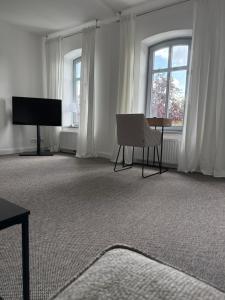un salon avec une chaise et une télévision dans l'établissement Edelhof1877, à Thedinghausen