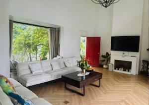 a living room with a white couch and a table at Solmist Villa in Suối Sao