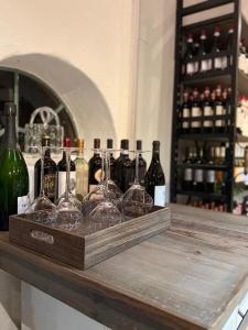 - un plateau en bois avec des bouteilles de vin et des verres sur un comptoir dans l'établissement Edelhof1877, à Thedinghausen
