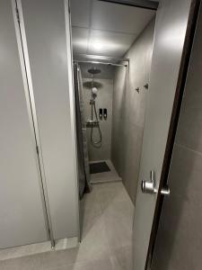 a bathroom with a shower with a door open at City Center Hostel in Mažeikiai