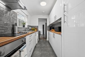 una cocina con armarios blancos y encimeras de madera en NEW! 4BR 4BATH, Perfect for Contractors, Smart TVs, WiFi, en Coventry