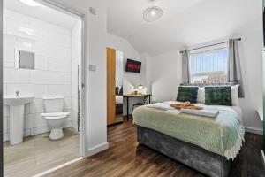 Un dormitorio con una cama, un lavabo y un inodoro. en NEW! 4BR 4BATH, Perfect for Contractors, Smart TVs, WiFi, en Coventry