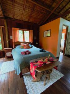 a bedroom with a bed and a table in it at Chalé Solar no Matutu in Aiuruoca