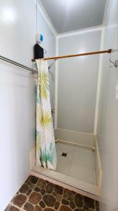 a shower with a shower curtain in a bathroom at Tez's Backpacking Lodge in Maria