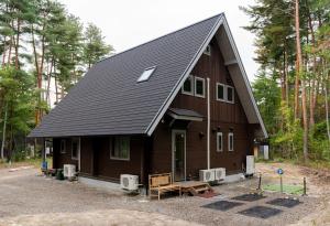 a large wooden house with a gambrel roof at Azumino Bear's Inn in Azumino