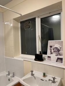 a bathroom with two sinks and a window at Manchester G Escape in Manchester