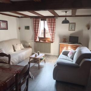 a living room with a couch and a table at Gite Anne & Jean-Paul in Cleebourg