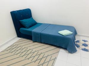 a blue chair sitting in a room with a rug at Mahligai Haza 2- Gambang in Gambang