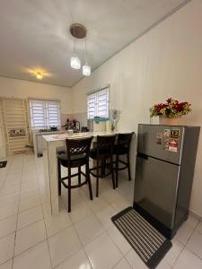 a kitchen with a table and chairs and a refrigerator at Mahligai Haza 2- Gambang in Gambang