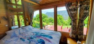 a bedroom with a bed and a large window at Remote Tiny House Retreat in Rimetea