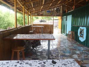 a restaurant with a table and chairs on a tiled floor at Tez's Backpacking Lodge in Maria