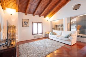 ein Wohnzimmer mit einer weißen Couch und einem Teppich in der Unterkunft Centralissimo vista Municipio, Elegante con Rooftop in Pordenone