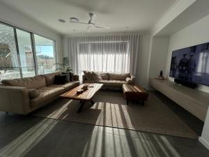 een woonkamer met een bank en een tafel bij Sugar Shore Retreat in Cudgen +10 foto's