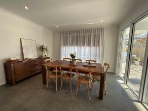 een eetkamer met een houten tafel en stoelen bij Sugar Shore Retreat in Cudgen