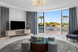 a living room with a flat screen tv and a table at Pickalbatros Golf Luxury Suites - All Inclusive in Sharm El Sheikh