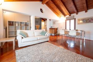 ein Wohnzimmer mit einer weißen Couch und einem Tisch in der Unterkunft Centralissimo vista Municipio, Elegante con Rooftop in Pordenone