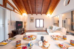 ein Wohnzimmer mit einem Tisch mit Essen drauf in der Unterkunft Centralissimo vista Municipio, Elegante con Rooftop in Pordenone