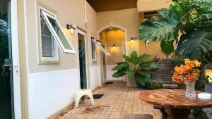 a patio with a table and a door with flowers at Rimklong boutique hotel trad in Trat