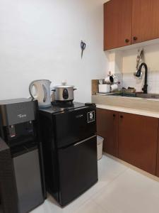a kitchen with a black refrigerator and a stove at Marinduque Apartment in Tagum