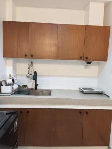 a kitchen with wooden cabinets and a sink at Marinduque Apartment in Tagum +6 photos