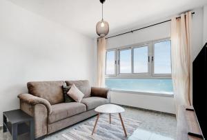 a living room with a couch and a window at wonderful tila house, facing the sea in La Garita