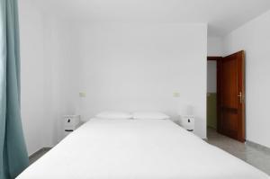 a large white bed in a room with a door at wonderful tila house, facing the sea in La Garita