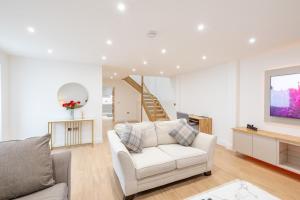 a living room with a white couch and a television at Granite cottage in Isle of Jersey