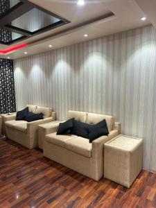 カラチにあるMeetUp Karachiのリビングルーム(壁の前にソファ2台付) +2枚の写真