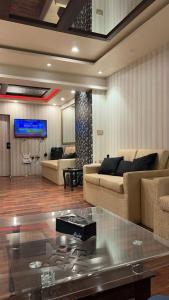 een woonkamer met twee banken en een tv bij MeetUp Karachi in Karachi