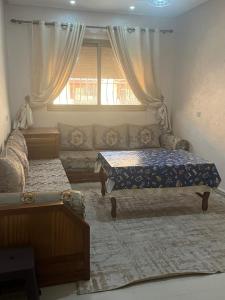 a living room with two beds and a window at avenue hassan 2 agadir in Oulad Akkou