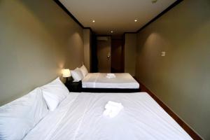 two beds in a hotel room with white sheets at HY Local Budget Hotel - 5 mins walk to Hoi An Ancient Town in Hoi An