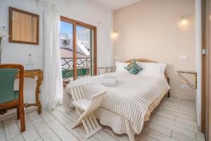 a bedroom with a bed with a chair and a window at Alvor Ar de Mar Apart in Alvor