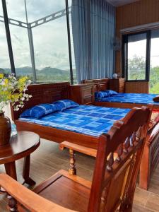 a bedroom with two beds and a table at Kala view homestay in Di Linh