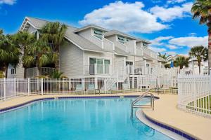 une villa avec piscine et palmiers dans l'établissement The Salty C Shell by Pristine Properties Vacation Rentals, à Mexico Beach