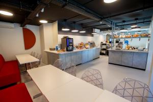 a restaurant with tables and chairs and a kitchen at ibis budget Haguenau Strasbourg Nord in Haguenau