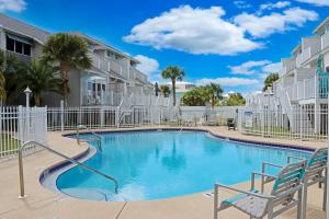 - une piscine avec des chaises dans un complexe dans l'établissement The Salty C Shell by Pristine Properties Vacation Rentals, à Mexico Beach